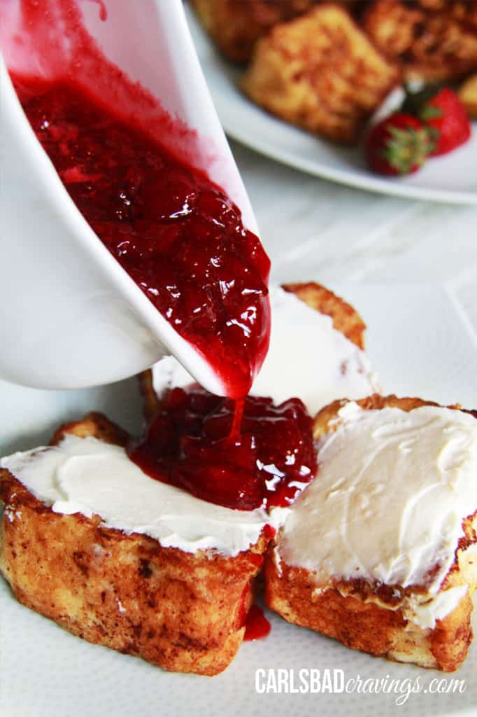 Angel Food Cake French Toast with strawberry syrup over top three pieces on a white plate.