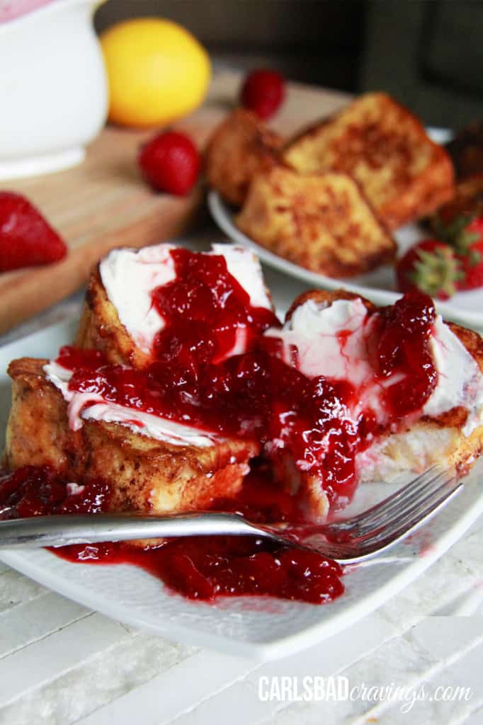 A plated photo of Angel Food Cake French Toast with strawberry syrup over top on a white plate.