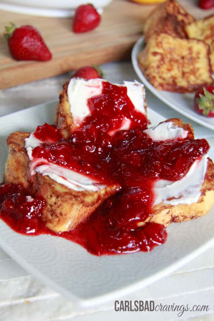 Angel Food Cake French Toast covered in strawberry syrup on a white plate.