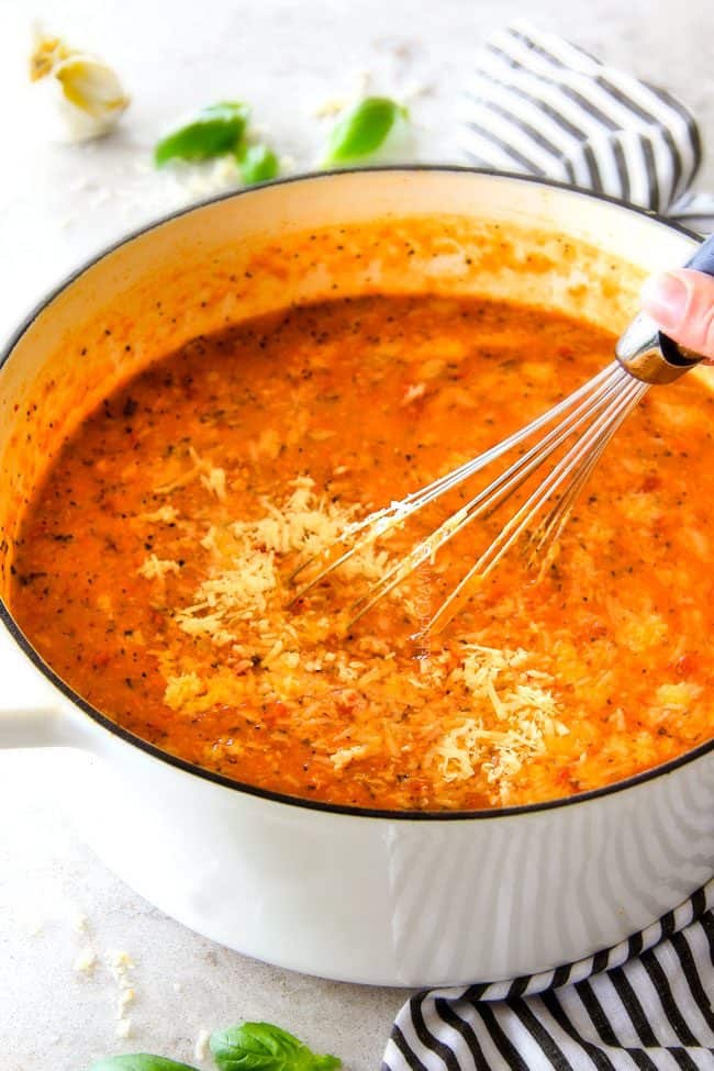 showing how to make Tomato Basil Soup recipe by whisking in Parmesan
