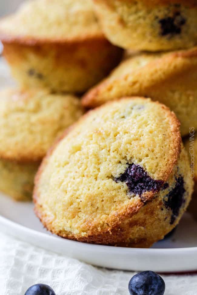 close up of blueberry corn muffins on a white plate 