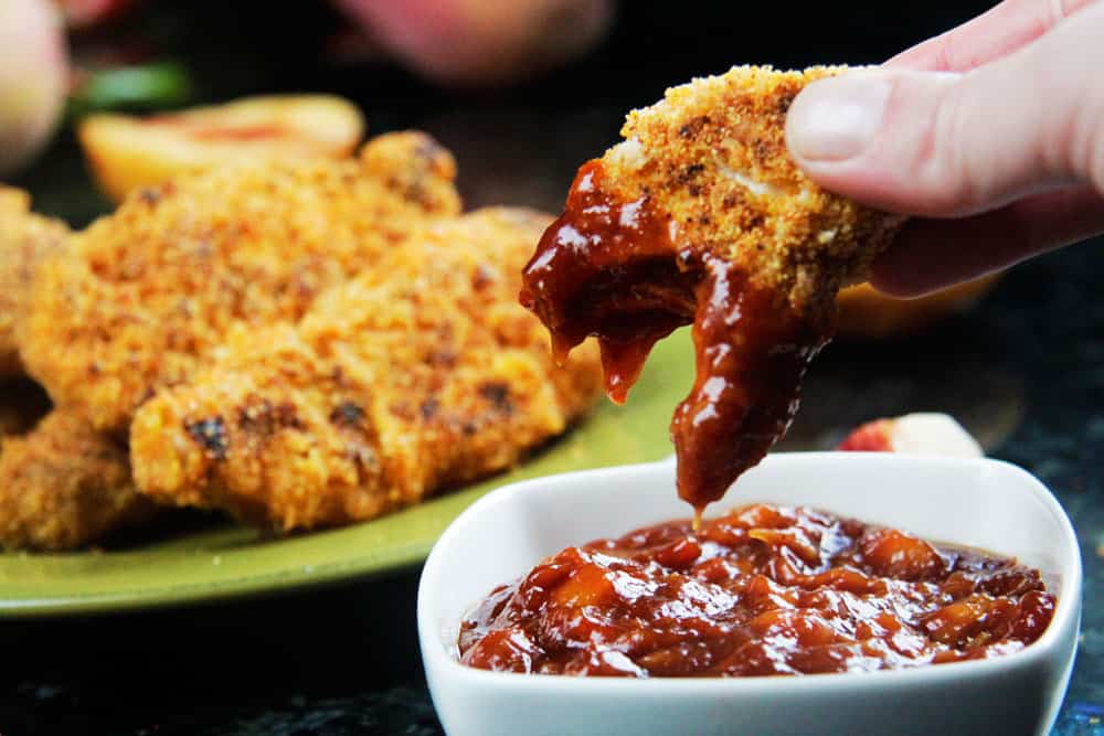 showing how how to make spicy chicken tenders by dipping in homemade barbecue sauce