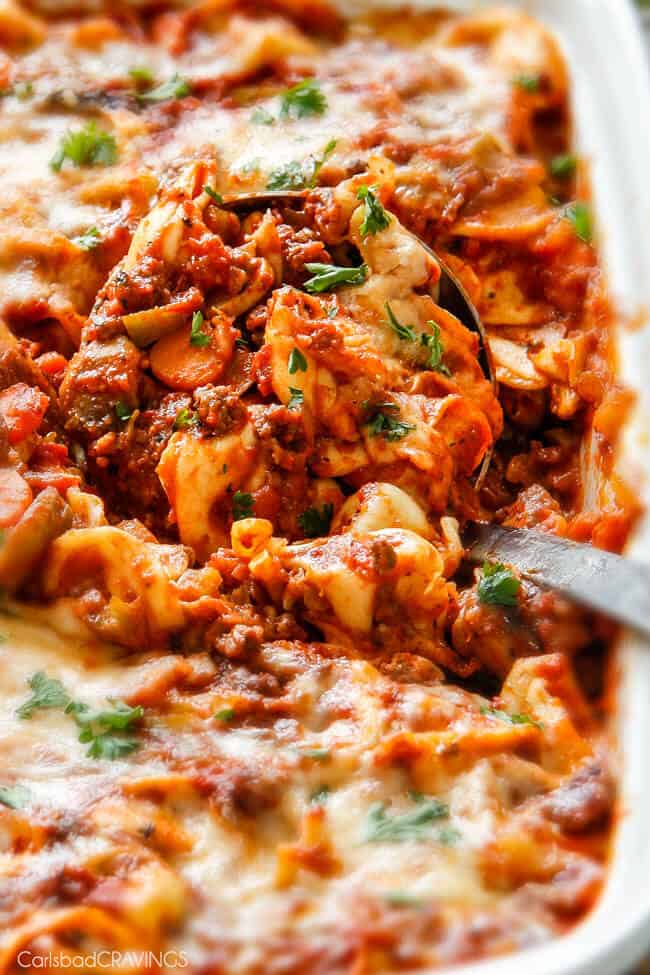 A close up of Cheesy Tortellini being served with a spoon.