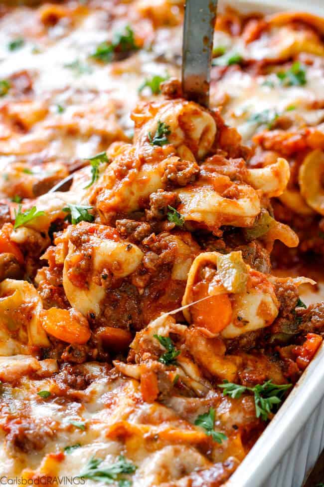 Cheesy Tortellini in a pan being served. 