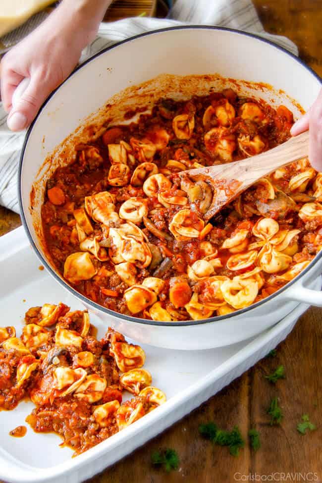 Adding Cheesy Tortellini to a pan to bake.