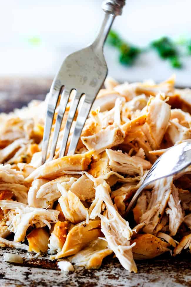 Shredding chicken on cutting board for Slow Cooker Chicken Tortellini Soup