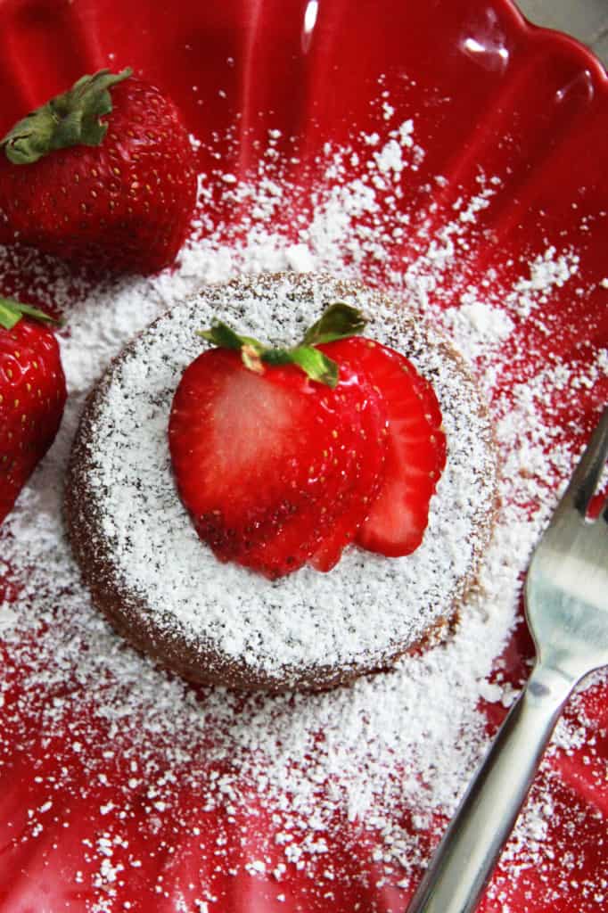 top view of molten lava cake with powdered sugar on a red plate