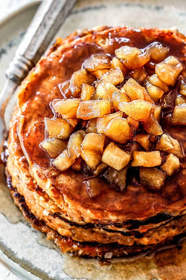 up close view of chunky cinnamon apple syrup on top of a stack of sweet potato pancakes