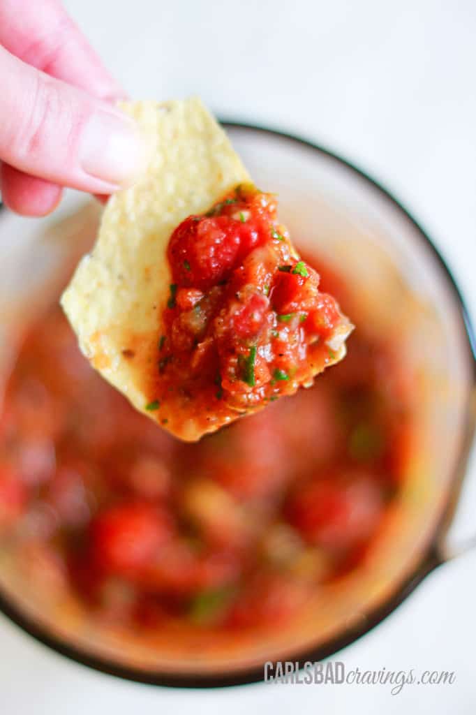 showing how to make homemade salsa by blending tomatoes and green chils until smooth