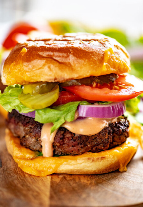 The ultimate burger recipe piled with lettuce, red onions, tomatoes and lettuce
