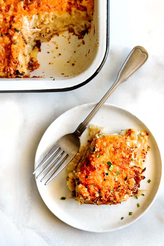 Scalloped Potatoes & Au Gratin with Bacon serving on a plate with a fork. 