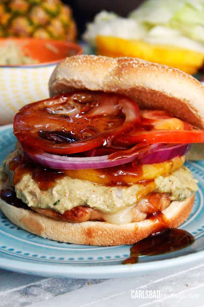 front view of Hawaiian Teriyaki Chicken Sandwich on a blue plate with teriyaki sauce drizzling down the front