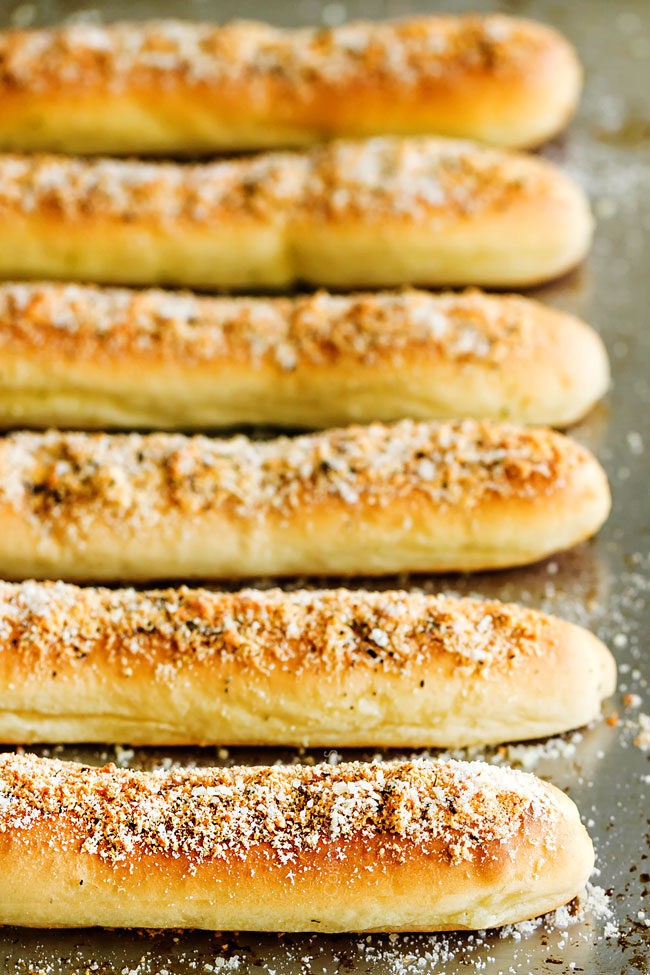 showing how to make best homemade breadsticks by lining breadsticks on a baking sheet