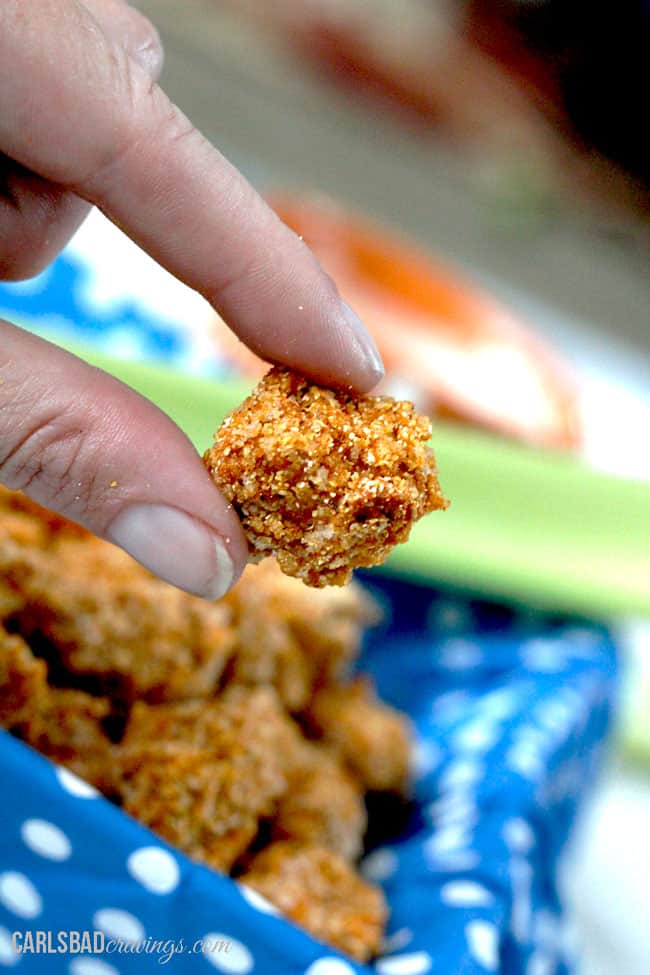 dipping a piece of crunchy popcorn chicken into dipping sauce