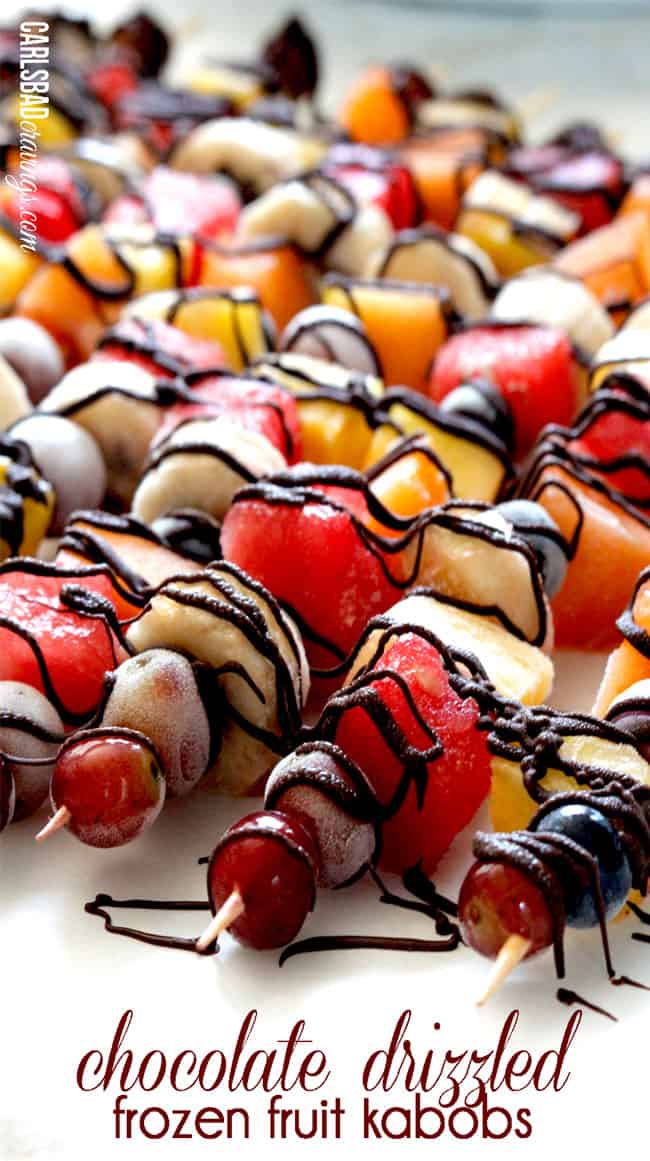 side view of fruit skewers on a white cutting board 