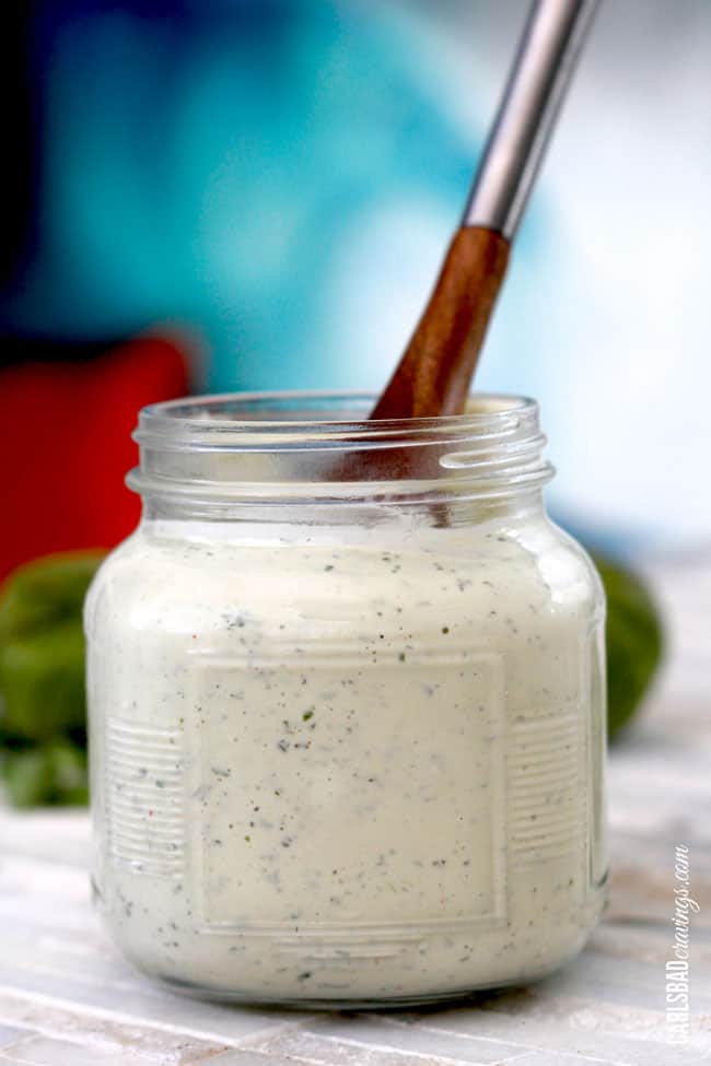 a wooden spoon in avocado lime ranch dressing 
