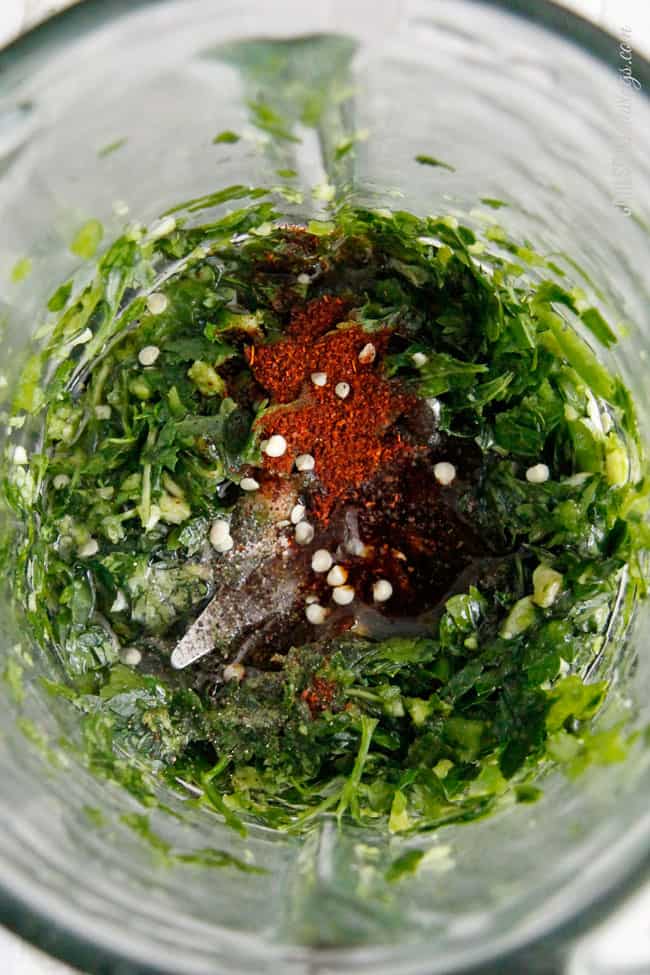 showing how to make chimichurri by  adding salt and pepper to chimichurri