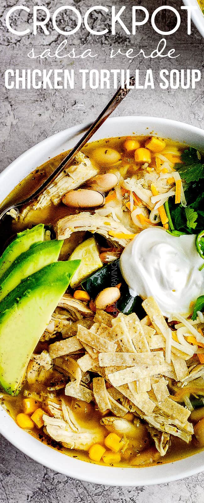 top up close of crockpot chicken torilla soup garnished with sour cream, avocados, cilantro and tortilla strips