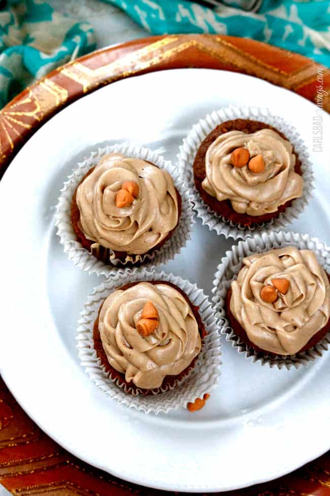 four pumpkin spice cupcakes on a white platter