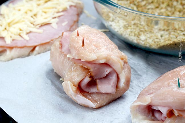 showing how to make chicken cordon bleu by rolling up chicken and securing with toothpicks
