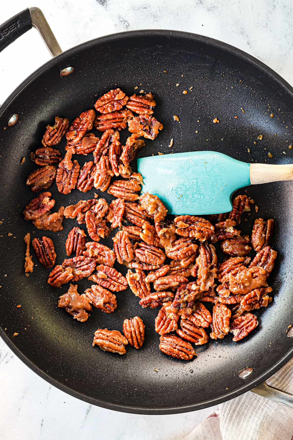 Showing how to make caramelized (candied Nuts) in a pan with butter with mixing the butter and sugar in a pan.