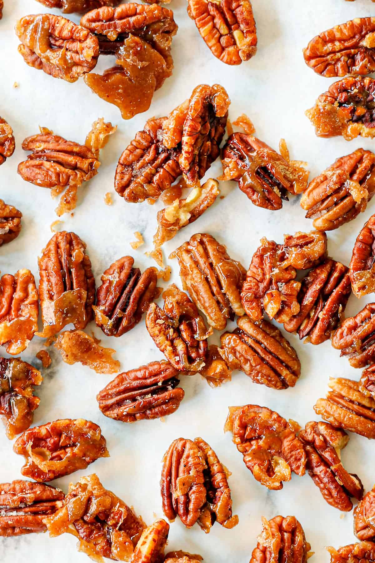 showing how to make caramelized nuts by cooling on parchment paper