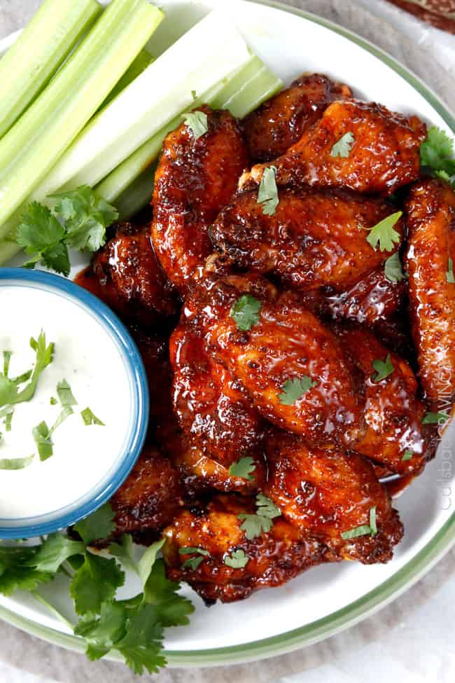 Top view of Honey Buffalo Hot Wings  on a plate with celery and blue cheese dipping sauce. 
