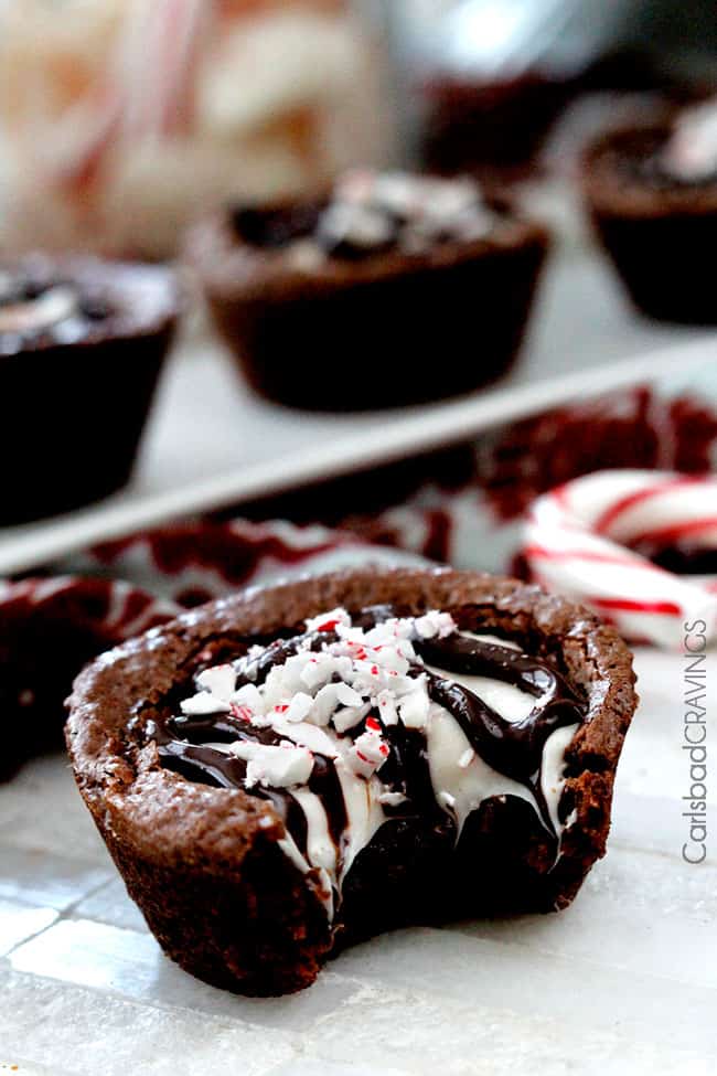 A Peppermint Eggnog Brownie Cups with a bite out of it garnished with candy canes.