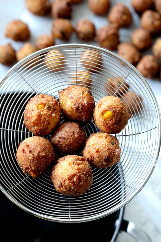 showing how to make easy hush puppy recipe by taking hush puppies out of fryer with a slotted spoon