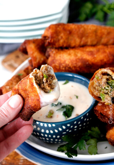 Philly Cheesesteak Egg Rolls dipped in alfredo sauce..