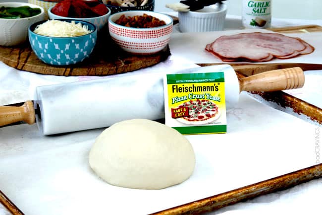 showing how to make stromboli by adding pizza dough to parchment paper