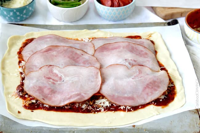 showing how to make Stromboli by layering pepperoni with ham
