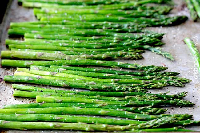 raw asparagus on baking sheet showing how to make balsamic asparagus