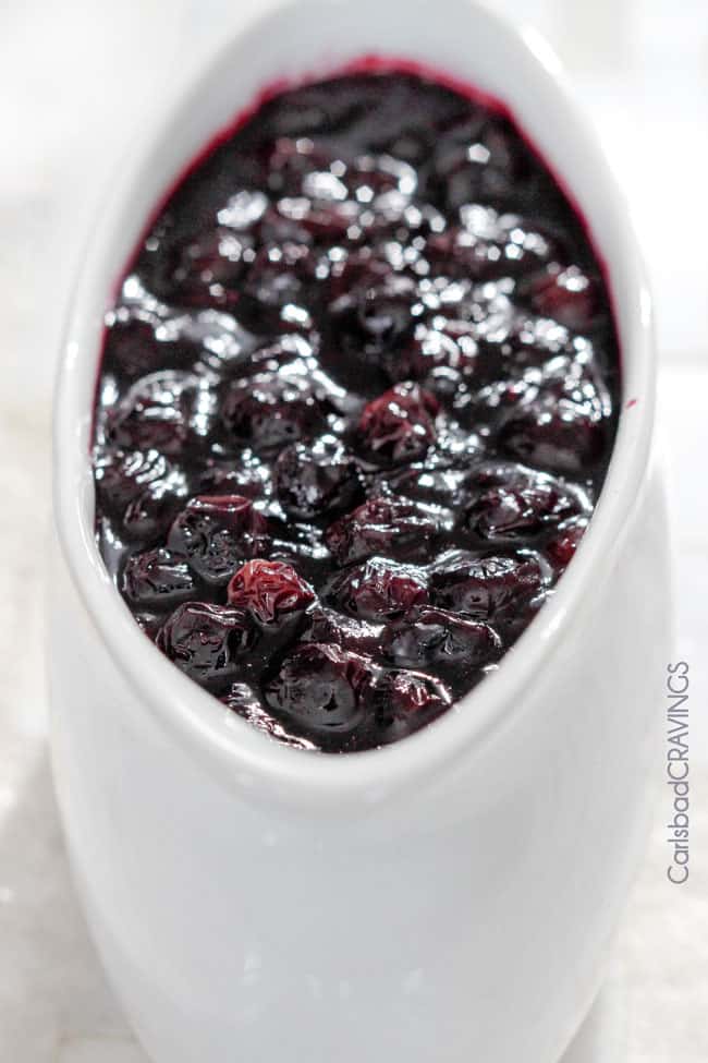 up close of homemade blueberry sauce in a white serving dish