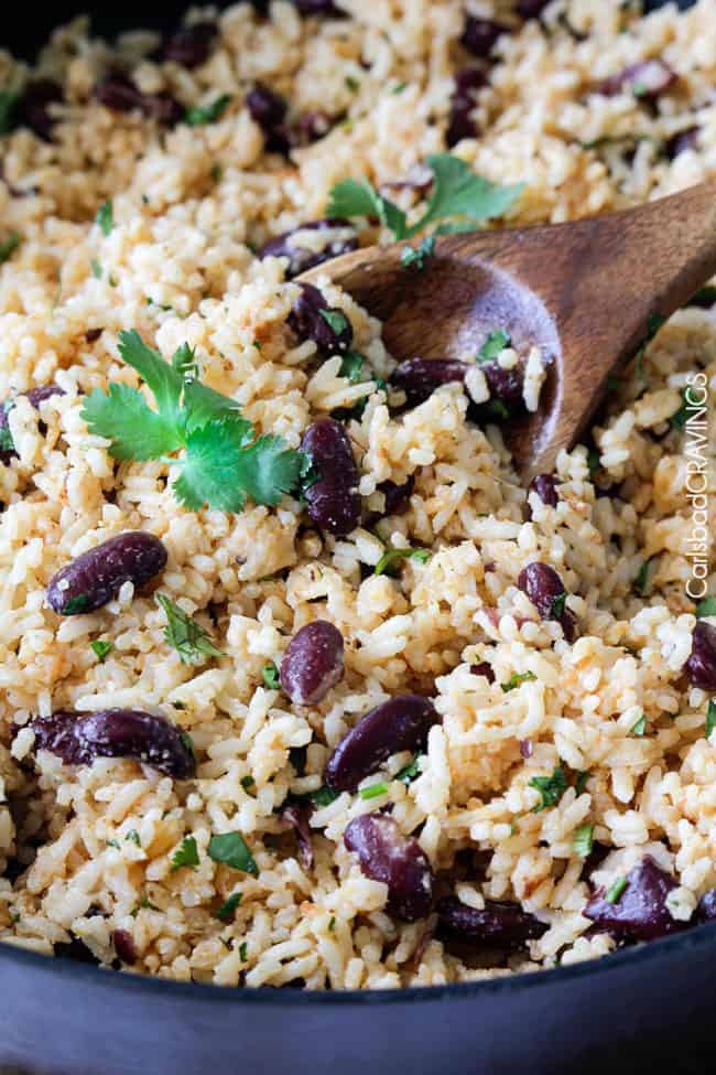close up of rice and beans with wooden spoon