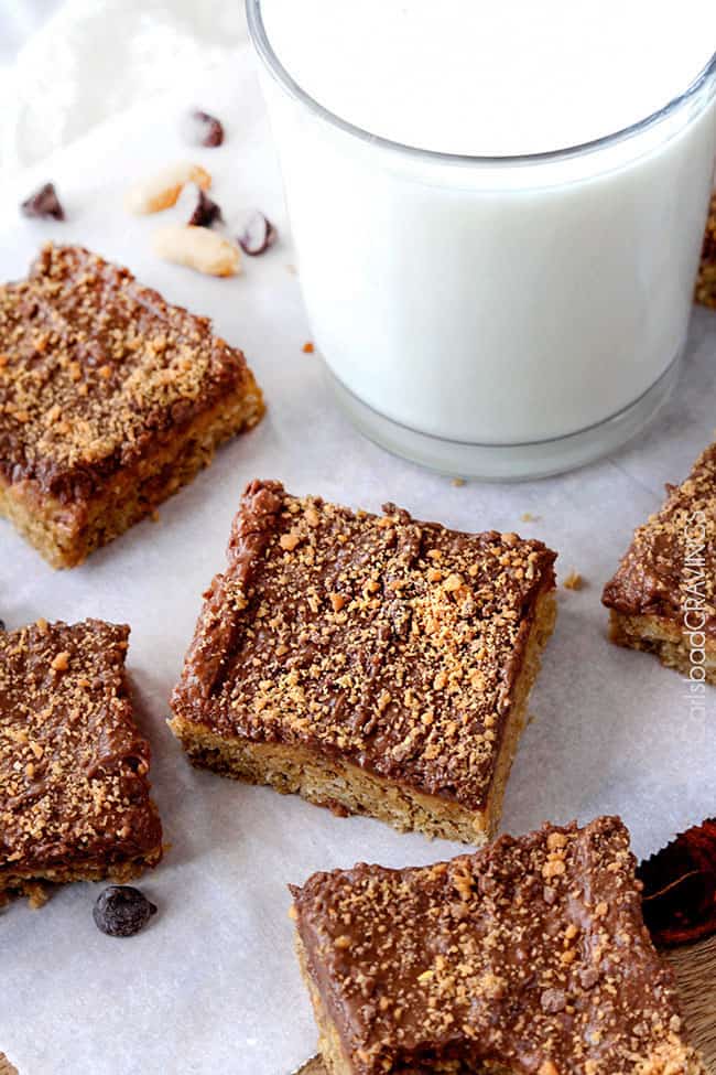 Several Peanut Butter Cookie Bars next to a cup of milk.