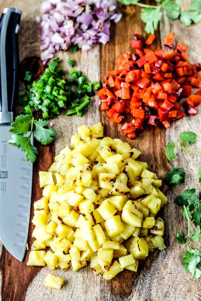 Showing how to make Home made Pineapple Salsa by chopping up grilled vegetables and fruits.