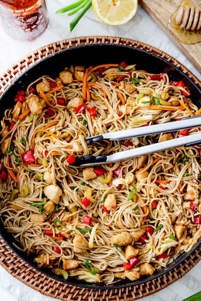 overhead view of spicy chicken stir fry with noodles in a skillet. 