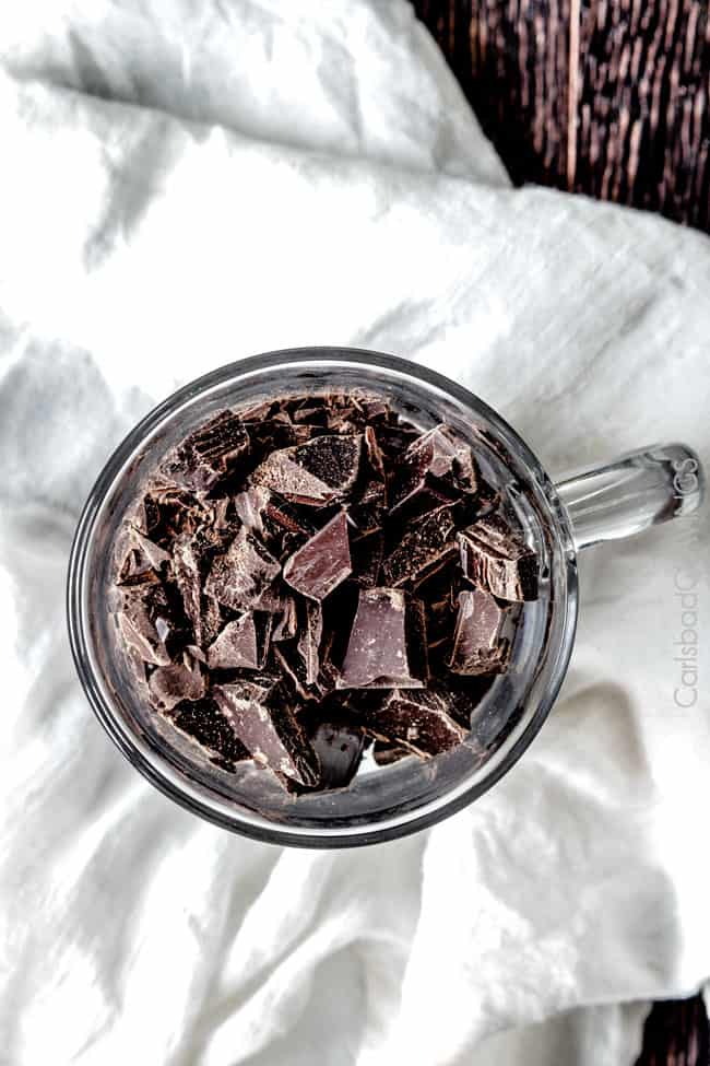 Showing how to make Chocolate Sauce by putting chocolate chunks in a glass measuring bowl. 