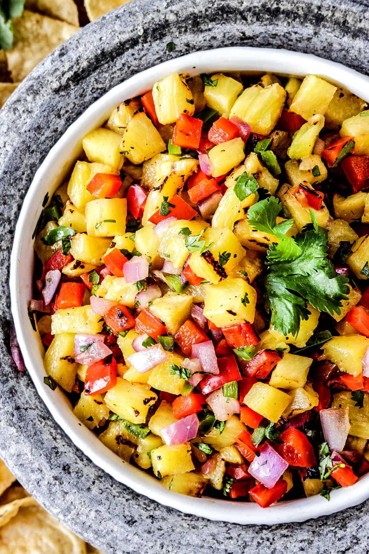 showing how to make pineapple chicken tacos by making pineapple salsa