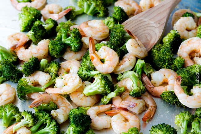 showing how to make healthy Shrimp Alfredo Recipe by stirring roasted shrimp and broccoli