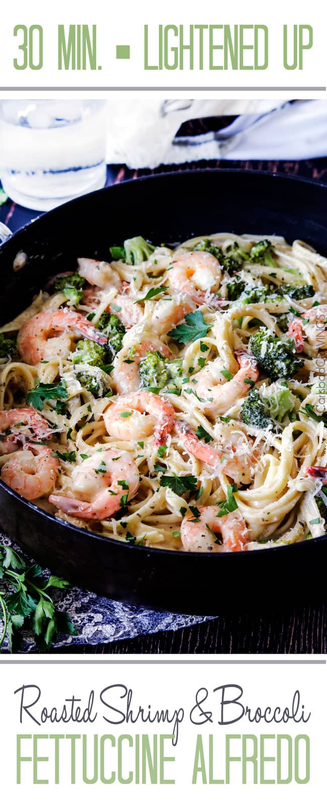 Shrimp Fettuccine Alfredo with broccoli in a black skillet garnished with Parmesan