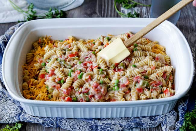 Showing how to make Cajun Tuna Casserole by adding the pasta to a casserole dish.