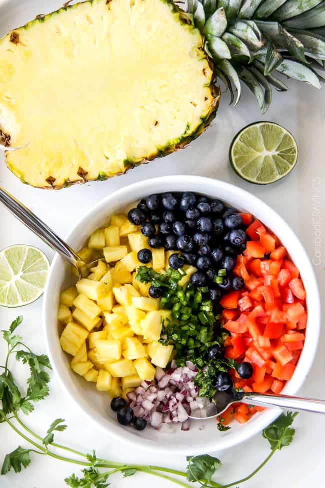 Showing how to make Blueberry Pineapple Salsa in a bowl. 