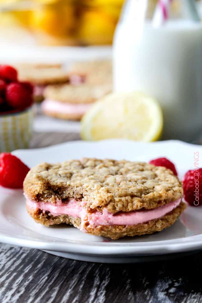The spring/summer version of BETTER THAN ORIGINAL Little Debbies Oatmeal Creme Pies! Two large, soft, chewy buttery lemon oatmeal cookies sandwiching creamy raspberry frosting. You won't believe how good these are! #oatmeal #cookies #raspberry #lemon #littledebbies