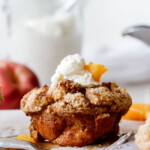 Baked Peaches and Cream French Toast Muffins are an irresistible STRESS FREE make-ahead breakfast bursting with sweet peaches, crowned with Cinnamon Streusel, doused with syrup and topped with luscious cream! !