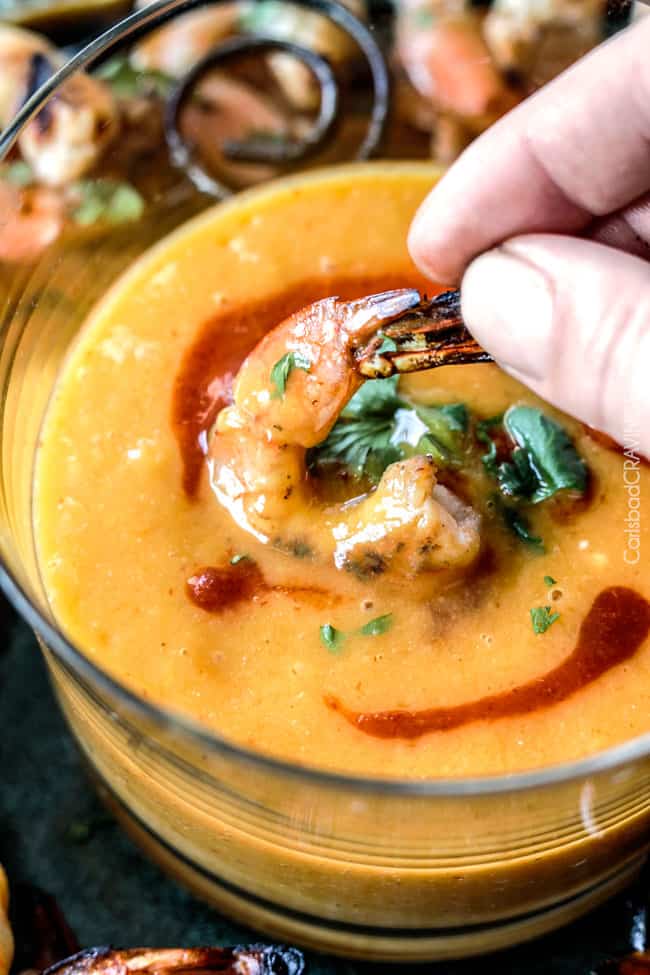 Dipping Coconut Honey Lime Shrimp into sauce.