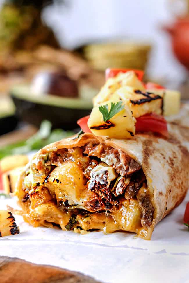 side up close front view of a California Burrito with french fries, carne asada, sour cream and guacamole 