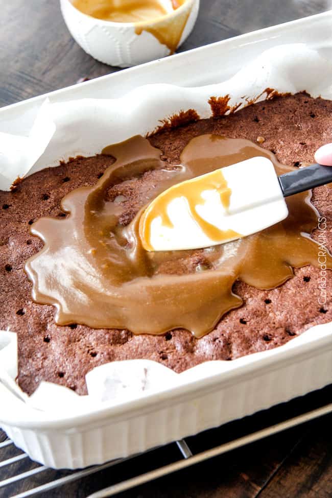 showing how to make Turtle Brownies by spreading caramel with a spatula into the poke holes