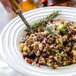 Easy one pot Cranberry Apple Pecan Rice Pilaf simmered in herb seasoned chicken broth and apple juice and riddled with sweet dried cranberries, apples and roasted pecans for an unbelievable savory sweet side dish perfect for the holidays. Everyone always asks for this recipe!